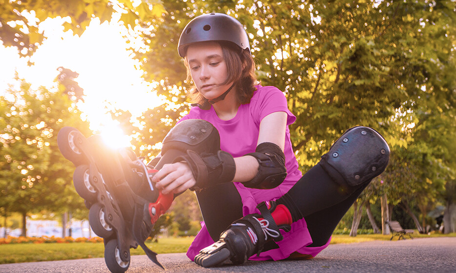 Mädchen zieht sich Inline Skates an