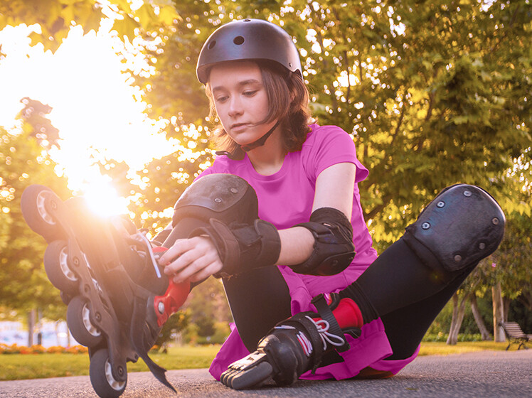 Mädchen zieht sich Inline Skates an